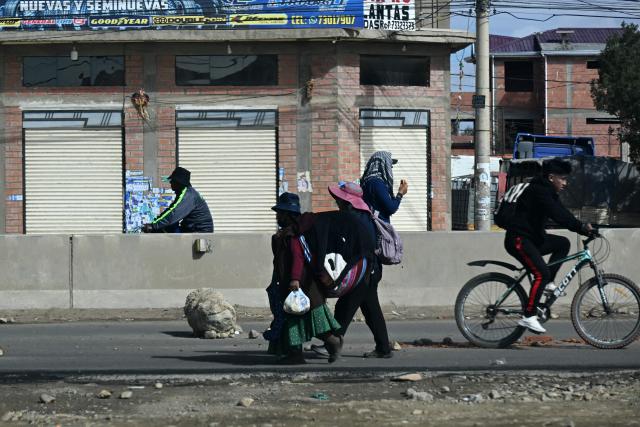 People ride past roadblocks against the government of Bolivian President Rodrigo Paz, in El Alto, Bolivia, on May 23, 2026. The Bolivian government said it would deploy a police and military operation starting on the morning of May 23 to allow the passage of scarce goods into La Paz through roadblocks, as unions and Indigenous groups press their calls for President Rodrigo Paz to step down. (Photo by AIZAR RALDES / AFP)