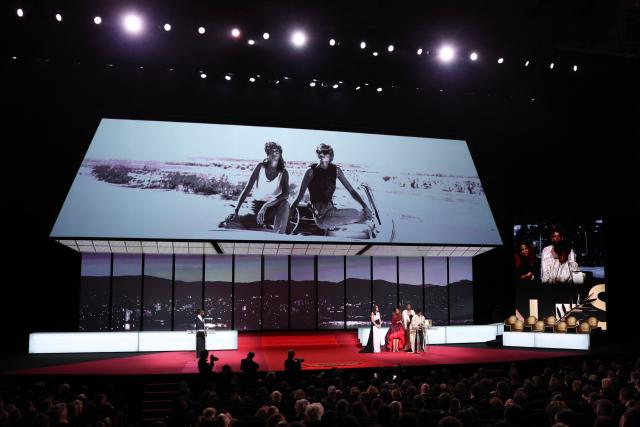 Rwandan director and screenwriter Marie-Clementine Dusabejambo (R) celebrates on stage after winning the Camera d'Or Prize for the film "Ben'Imana" during the closing ceremony of the 79th edition of the Cannes Film Festival in Cannes, southern France, on May 23, 2026. (Photo by Sameer AL-DOUMY / AFP)