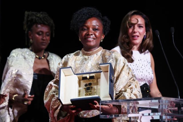 Rwandan director and screenwriter Marie-Clementine Dusabejambo (C) celebrates on stage after winning the Camera d'Or Prize for the film "Ben'Imana" during the closing ceremony of the 79th edition of the Cannes Film Festival in Cannes, southern France, on May 23, 2026. (Photo by Valery HACHE / AFP)