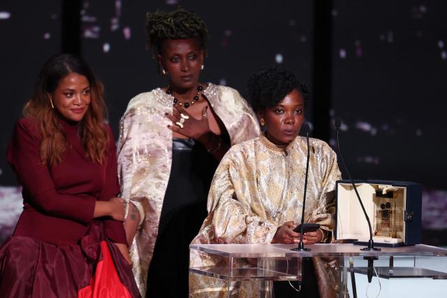 Rwandan actress Isabelle Kabano (C) and Rwandan director and screenwriter Marie-Clementine Dusabejambo (R) celebrate on stage after winning the Camera d'Or Prize for the film "Ben'Imana" during the closing ceremony of the 79th edition of the Cannes Film Festival in Cannes, southern France, on May 23, 2026. (Photo by Sameer AL-DOUMY / AFP)