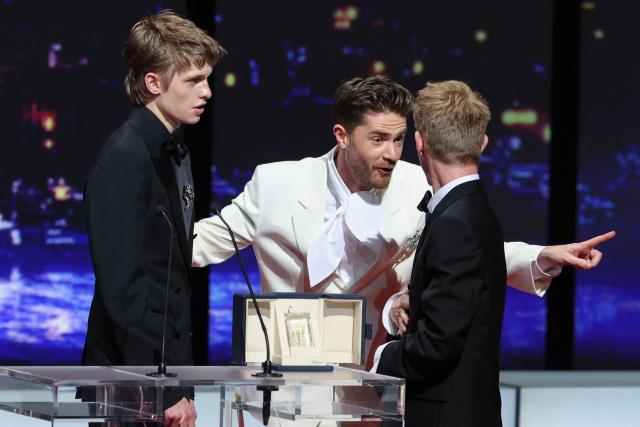 Belgian actor Emmanuel Macchia (L) and French actor Valentin Campagne celebrate with Belgian director Lukas Dhont on stage after winning ex-aequo the Best Actor Prize for the film "Coward" during the closing ceremony of the 79th edition of the Cannes Film Festival in Cannes, southern France, on May 23, 2026. (Photo by Sameer AL-DOUMY / AFP)