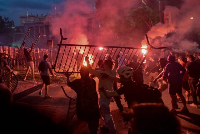 A group of demonstrators clash with riot police outside Serbia's parliament building at the end of an anti-government protest decrying corruption and calling for early elections following the collapse of a railway station canopy in Novi Sad that killed 16 in November 2024, in central Belgrade on May 23, 2026. (Photo by OLIVER BUNIC / AFP)