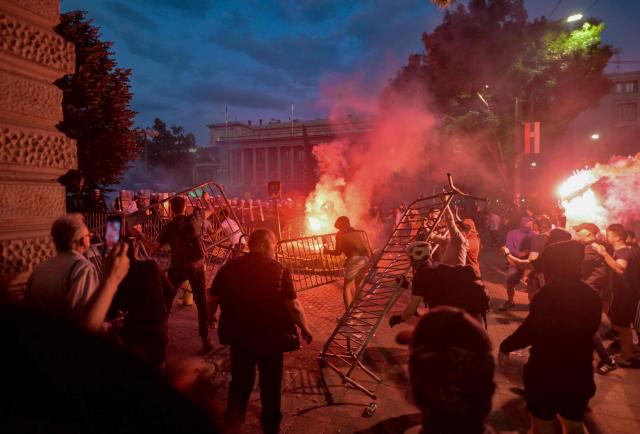 A group of demonstrators clash with riot police outside Serbia's parliament building at the end of an anti-government protest decrying corruption and calling for early elections following the collapse of a railway station canopy in Novi Sad that killed 16 in November 2024, in central Belgrade on May 23, 2026. (Photo by OLIVER BUNIC / AFP)