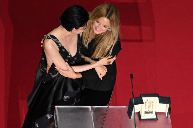 Japanese actress Tao Okamoto (L) and Belgian actress Virginie Efira (R) celebrate on stage after winning ex-aequo the Best Actress Prize for the film "Soudain" (All of a Sudden) during the closing ceremony of the 79th edition of the Cannes Film Festival in Cannes, southern France, on May 23, 2026. (Photo by Antonin THUILLIER / AFP)