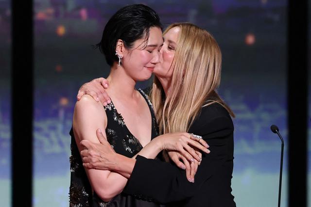 Japanese actress Tao Okamoto (L) and Belgian actress Virginie Efira celebrate on stage after winning ex-aequo the Best Actress Prize for the film "Soudain" (All of a Sudden) during the closing ceremony of the 79th edition of the Cannes Film Festival in Cannes, southern France, on May 23, 2026. (Photo by Sameer AL-DOUMY / AFP)