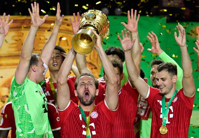 Bayern Munich's English forward #09 Harry Kane lifts the trophy after the German Cup (DFB Pokal) final football match FC Bayern Munich v VfB Stuttgart at the Olympic Stadium in Berlin, on May 23, 2026. (Photo by John MACDOUGALL / AFP) / DFB REGULATIONS PROHIBIT ANY USE OF PHOTOGRAPHS AS IMAGE SEQUENCES AND QUASI-VIDEO.