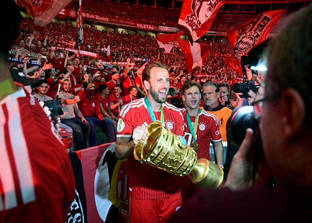 Bayern Munich's English forward #09 Harry Kane and his teammates celebrate with the trophy in front of their fans after the German Cup (DFB Pokal) final football match FC Bayern Munich v VfB Stuttgart at the Olympic Stadium in Berlin, on May 23, 2026. (Photo by Tobias SCHWARZ / AFP) / DFB REGULATIONS PROHIBIT ANY USE OF PHOTOGRAPHS AS IMAGE SEQUENCES AND QUASI-VIDEO.
