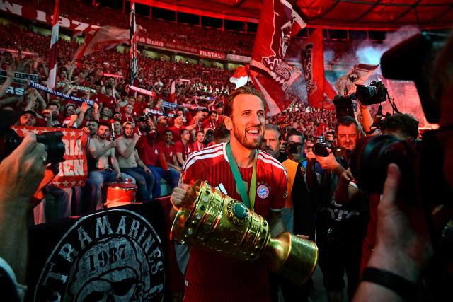 Bayern Munich's English forward #09 Harry Kane and his teammates celebrate with the trophy in front of their fans after the German Cup (DFB Pokal) final football match FC Bayern Munich v VfB Stuttgart at the Olympic Stadium in Berlin, on May 23, 2026. (Photo by Tobias SCHWARZ / AFP) / DFB REGULATIONS PROHIBIT ANY USE OF PHOTOGRAPHS AS IMAGE SEQUENCES AND QUASI-VIDEO.