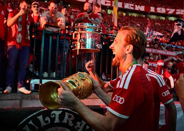 Bayern Munich's English forward #09 Harry Kane and his teammates celebrate with the trophy in front of their fans after the German Cup (DFB Pokal) final football match FC Bayern Munich v VfB Stuttgart at the Olympic Stadium in Berlin, on May 23, 2026. (Photo by Tobias SCHWARZ / AFP) / DFB REGULATIONS PROHIBIT ANY USE OF PHOTOGRAPHS AS IMAGE SEQUENCES AND QUASI-VIDEO.