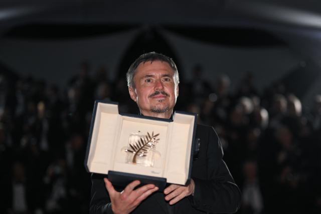 Romanian director, screenwriter and producer Cristian Mungiu poses with the trophy during a photocall after winning the Palme d'Or for the film "Fjord" during the closing ceremony of the 79th edition of the Cannes Film Festival in Cannes, southern France, on May 23, 2026. (Photo by Olivier CHASSIGNOLE / AFP)