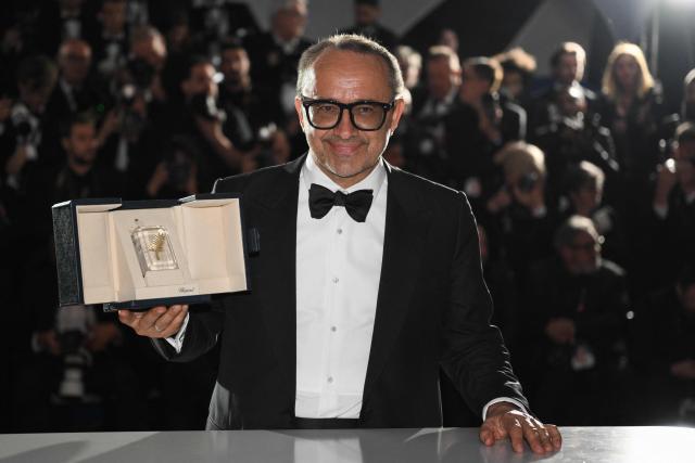 Romanian director, screenwriter and producer Cristian Mungiu poses with the trophy during a photocall after winning the Palme d'Or for the film "Fjord" during the closing ceremony of the 79th edition of the Cannes Film Festival in Cannes, southern France, on May 23, 2026. (Photo by Olivier CHASSIGNOLE / AFP)