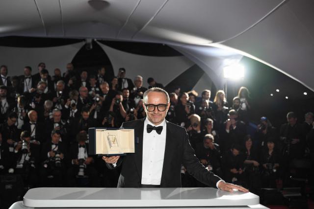 Romanian director, screenwriter and producer Cristian Mungiu poses with the trophy during a photocall after winning the Palme d'Or for the film "Fjord" during the closing ceremony of the 79th edition of the Cannes Film Festival in Cannes, southern France, on May 23, 2026. (Photo by Olivier CHASSIGNOLE / AFP)