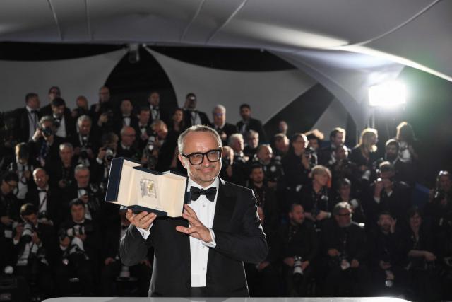 Romanian director, screenwriter and producer Cristian Mungiu poses with the trophy during a photocall after winning the Palme d'Or for the film "Fjord" during the closing ceremony of the 79th edition of the Cannes Film Festival in Cannes, southern France, on May 23, 2026. (Photo by Olivier CHASSIGNOLE / AFP)