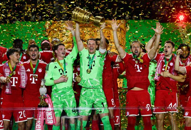 Bayern Munich's German goalkeeper #01 Manuel Neuer lifts the trophy after the German Cup (DFB Pokal) final football match FC Bayern Munich v VfB Stuttgart at the Olympic Stadium in Berlin, on May 23, 2026. (Photo by John MACDOUGALL / AFP) / DFB REGULATIONS PROHIBIT ANY USE OF PHOTOGRAPHS AS IMAGE SEQUENCES AND QUASI-VIDEO.