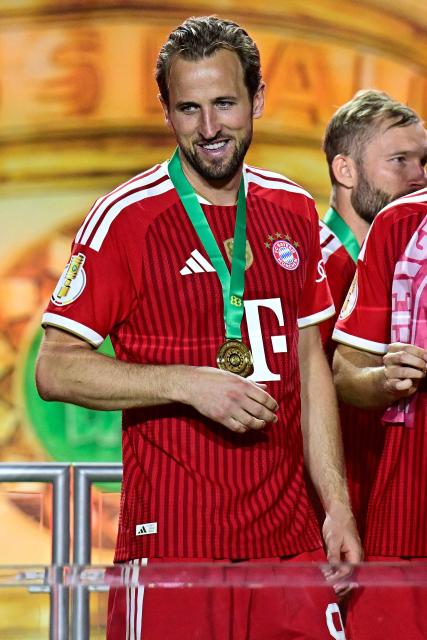 Bayern Munich's English forward #09 Harry Kane (L) and his teammates celebrate after the German Cup (DFB Pokal) final football match FC Bayern Munich v VfB Stuttgart at the Olympic Stadium in Berlin, on May 23, 2026. (Photo by Tobias SCHWARZ / AFP) / ALTERNATIVE CROP
