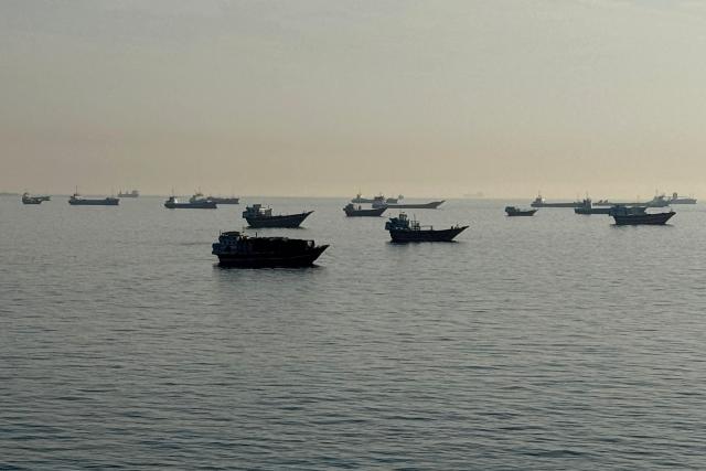 (FILES) Vessels are seen anchored in the Strait of Hormuz, off the port city of Khasab on Oman’s northern Musandam Peninsula on May 17, 2026. US President Donald Trump said on May 23 that Iran and the US had "largely negotiated" a deal that included opening the Strait of Hormuz, but the draft was "subject to finalization." (Photo by AFP) / 