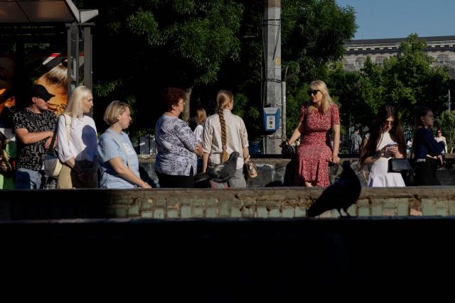 Residents wait at the tram stop in Kyiv on May 23, 2026, amid the Russian invasion of Ukraine. (Photo by Tetiana DZHAFAROVA / AFP)
