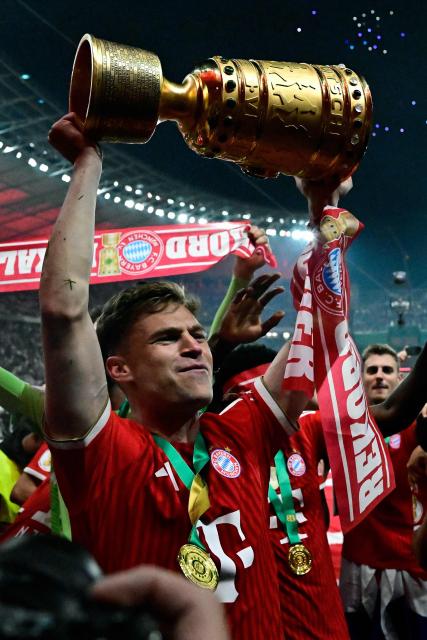 Bayern Munich's German midfielder #06 Joshua Kimmich and his teammates celebrate with the trophy in front of their fans after the German Cup (DFB Pokal) final football match FC Bayern Munich v VfB Stuttgart at the Olympic Stadium in Berlin, on May 23, 2026. (Photo by Tobias SCHWARZ / AFP) / ALTERNATIVE CROP