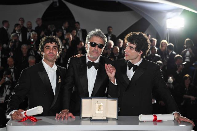 Spanish director, screenwriter and producer Javier Ambrossi (L), Polish writer Pawel Pawlikowski (C) and Spanish director, screenwriter and producer Javier Calvo (R) pose with the trophy during a photocall after winning ex-aequo the Best Director Prize for the film "La Bola Negra" and "Fatherland" during the closing ceremony of the 79th edition of the Cannes Film Festival in Cannes, southern France, on May 23, 2026. (Photo by Olivier CHASSIGNOLE / AFP)