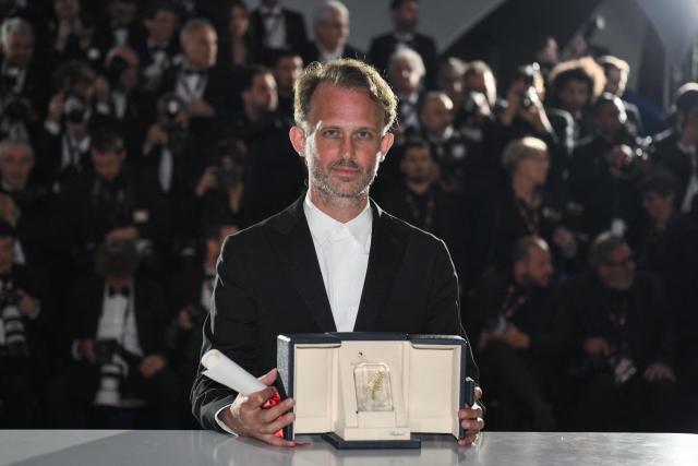 French director and screenwriter Emmanuel Marre poses with the trophy during a photocall after winning the Best Screenplay Prize for the film "Notre Salut" (A Man of His Time) during the closing ceremony of the 79th edition of the Cannes Film Festival in Cannes, southern France, on May 23, 2026. (Photo by Olivier CHASSIGNOLE / AFP)