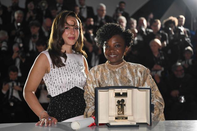 Rwandan director and screenwriter Marie-Clementine Dusabejambo (R) poses with the trophy next to President of the Camera d'Or jury Canadian actress, director and screenwriter Monia Chokri during a photocall after winning the Camera d'Or Prize for the film "Ben'Imana" during the closing ceremony of the 79th edition of the Cannes Film Festival in Cannes, southern France, on May 23, 2026. (Photo by Olivier CHASSIGNOLE / AFP)