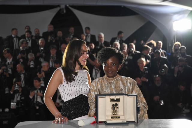Rwandan director and screenwriter Marie-Clementine Dusabejambo (R) poses with the trophy next to President of the Camera d'Or jury Canadian actress, director and screenwriter Monia Chokri during a photocall after winning the Camera d'Or Prize for the film "Ben'Imana" during the closing ceremony of the 79th edition of the Cannes Film Festival in Cannes, southern France, on May 23, 2026. (Photo by Olivier CHASSIGNOLE / AFP)