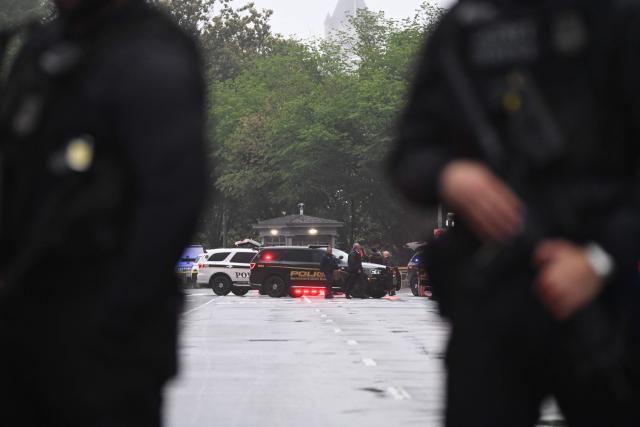 Police vehicles and armed officers are seen near the White House in Washington, DC, on May 23, 2026. Police and security forces swarmed the area around the White House on the evening of May 23 after reports of shots fired, AFP journalists said. US President Donald Trump was at the White House at the time as he worked to negotiate a deal with Iran. (Photo by Alex WROBLEWSKI / AFP)