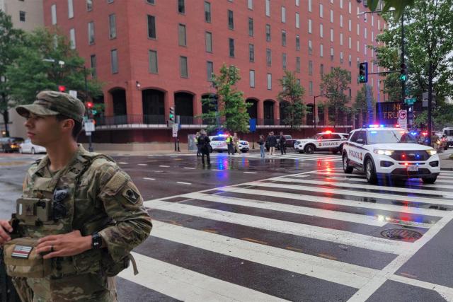 A National Guard member and police vehicles are seen on a blocked street near the White House in Washington, DC, on May 23, 2026. Police and security forces swarmed the area around the White House on the evening of May 23 after reports of shots fired, AFP journalists said. US President Donald Trump was at the White House at the time as he worked to negotiate a deal with Iran. (Photo by Ulysse BELLIER / AFP)