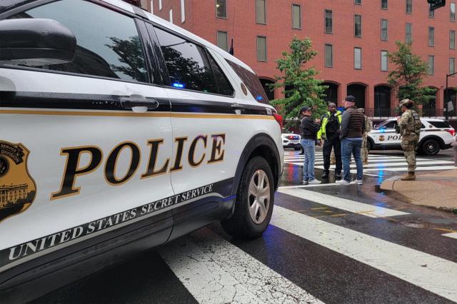 A National Guard member and police vehicles are seen on a blocked street near the White House in Washington, DC, on May 23, 2026. Police and security forces swarmed the area around the White House on the evening of May 23 after reports of shots fired, AFP journalists said. US President Donald Trump was at the White House at the time as he worked to negotiate a deal with Iran. (Photo by Ulysse BELLIER / AFP)