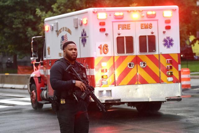 An armed Secret Service agent is seen next to an ambulance near the White House in Washington, DC, on May 23, 2026. Police and security forces swarmed the area around the White House on the evening of May 23 after reports of shots fired, AFP journalists said. US President Donald Trump was at the White House at the time as he worked to negotiate a deal with Iran. (Photo by Alex WROBLEWSKI / AFP)
