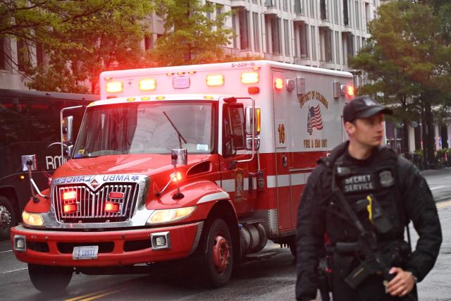 An armed Secret Service agent is seen next to an ambulance near the White House in Washington, DC, on May 23, 2026. Police and security forces swarmed the area around the White House on the evening of May 23 after reports of shots fired, AFP journalists said. US President Donald Trump was at the White House at the time as he worked to negotiate a deal with Iran. (Photo by Alex WROBLEWSKI / AFP)