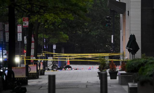 Police tape blocks off a crime scene with evidence markers seen on a sidewalk on 17th and Pennsylvania Ave near the White House in Washington, DC, on May 23, 2026. Police and security forces swarmed the area around the White House on the evening of May 23 after reports of shots fired, AFP journalists said. US President Donald Trump was at the White House at the time as he worked to negotiate a deal with Iran. (Photo by Alex WROBLEWSKI / AFP)