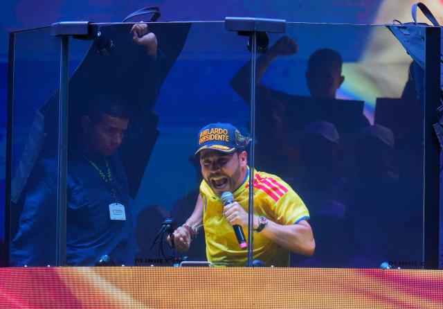 Colombia's presidential candidate for the Defensores de la Patria party, Abelardo de la Espriella, speaks behind a bulletproof glass during his last campaign rally in Barranquilla, Colombia on May 23, 2026. Colombia will hold presidential elections on May 31. (Photo by Vanessa ROMERO / AFP)