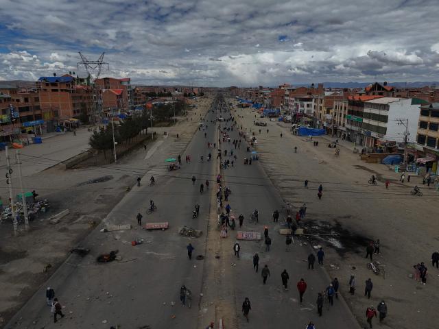 This aerial view shows demonstrators blocking a road during a protest against the government of Bolivian President Rodrigo Paz in El Alto, Bolivia, on May 23, 2026. The Bolivian government said it would deploy a police and military operation starting on the morning of May 23 to allow the passage of scarce goods into La Paz through roadblocks, as unions and Indigenous groups press their calls for President Rodrigo Paz to step down. (Photo by Marvin RECINOS / AFP)