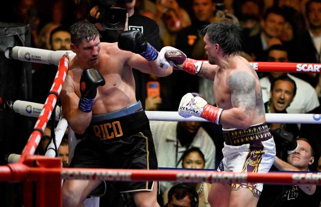 Ukraine's Oleksandr Usyk (R) throws a flurry of punches at Netherlands' Rico Verhoeven (L) before winning by TKO during their WBC World Heavyweight Championship 'Glory in Giza' boxing match at the Pyramids of Giza on May 23, 2026.  (Photo by Khaled DESOUKI / AFP)