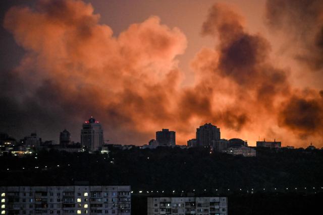 Smoke rises as the glow from fires light the sky during a Russian strike on the Ukrainian capital Kyiv on May 24, 2026, amid the Russian invasion in Ukraine. A large ballistic missile attack pounded Kyiv early on May 24, authorities said, wounding at least five people after Moscow threatened retaliation for strikes in Russian-occupied eastern Ukraine. (Photo by Evgen KOTENKO / AFP)