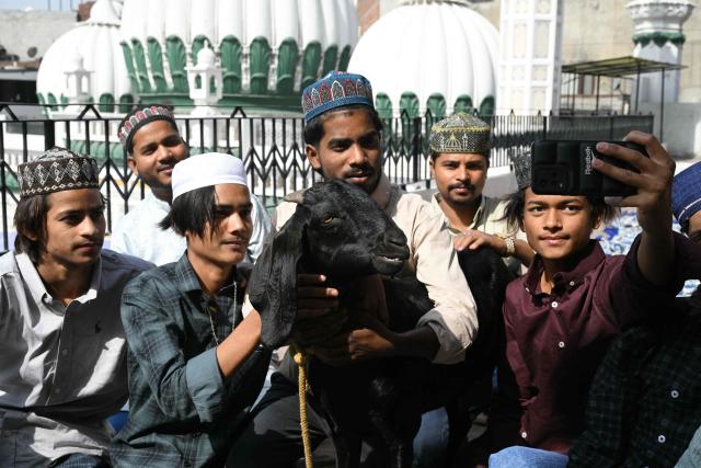 Muslim devotees take selfies with their goat after offering Eid al-Adha prayers at Jama Masjid Khairuddin in Amritsar on May 28, 2026. (Photo by Narinder NANU / AFP)