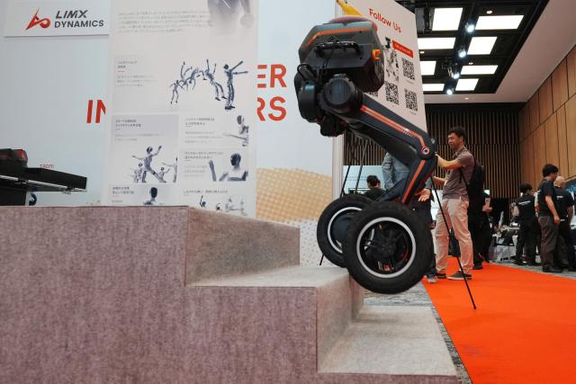 Multi-modal biped robot TRON1 from Limx Dynamics demonstrates climbing stairs at the Humanoids Summit Tokyo 2026 in Tokyo on May 28, 2026. (Photo by Kazuhiro NOGI / AFP)