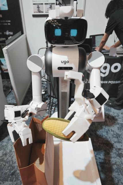 A humanoid robot, the ugo Pro Full Model, demonstrates the action of placing objects into a bag at the Humanoids Summit Tokyo 2026 in Tokyo on May 28, 2026. (Photo by Kazuhiro NOGI / AFP)