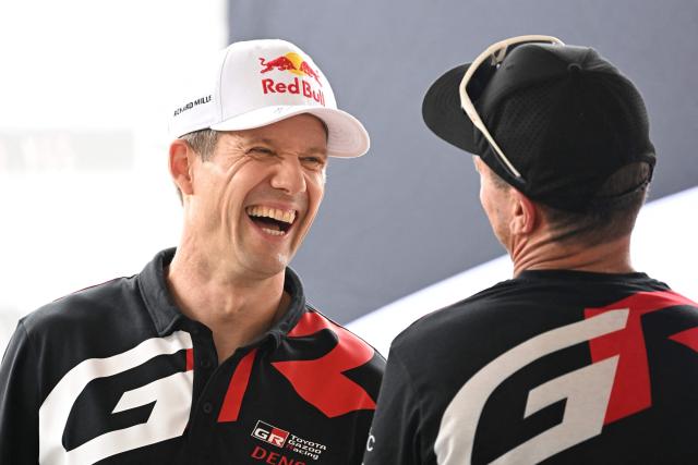 Toyota Gazoo Racing WRT team's Sebastien Ogier of France shares a light moment with his mechanic at his service pit in Toyota stadium during the Rally Japan, the 7th round of the FIA World Rally Championships in Toyota city, Aichi prefecture on May 28, 2026. (Photo by Toshifumi KITAMURA / AFP)