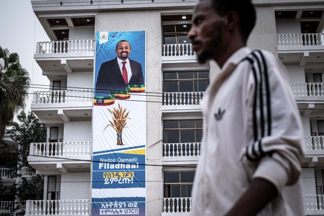 A man walks past an election campaign poster depicting Ethiopia’s Prime Minister Abiy Ahmed on May 27, 2026 ahead of Ethiopia’s general elections scheduled for June 1, 2026. (Photo by Marco Simoncelli / AFP)