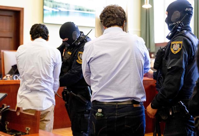 Defendants in handcuffs are escorted to the courtroom by justice officers as the verdict in a trial over a plot to attack a Taylor Swift concert in Vienna is awaited at a court in Wiener Neustadt, Austria, on May 28, 2026. The court in Wiener Neustadt, near Vienna, is set to deliver its verdict late May 28 afternoon in the case of a 21-year-old Austrian man accused of plotting an Islamist attack on a Taylor Swift concert. (Photo by Joe Klamar / AFP)