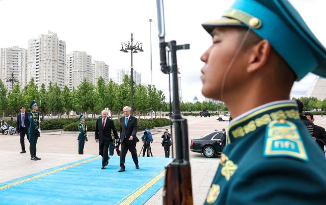 In this pool photograph distributed by the Russian state agency Sputnik Russian President Vladimir Putin (L) and Kazakh President Kassym-Jomart Tokayev (R) attend an official welcoming ceremony in front of the Palace of Independence in Astana on May 2026, as Putin is on a state visit to Kazakhstan. (Photo by Alexander KAZAKOV / POOL / AFP)