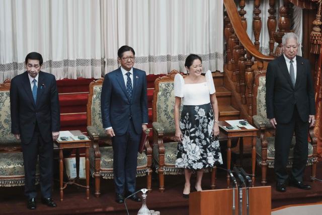 Philippines' President Ferdinand Marcos Jr. (2nd L) and First Lady Liza Araneta-Marcos (2nd R) are welcomed by Japanese parliamentarians at the National Diet in Tokyo on May 28, 2026. (Photo by Kazuhiro NOGI / AFP)