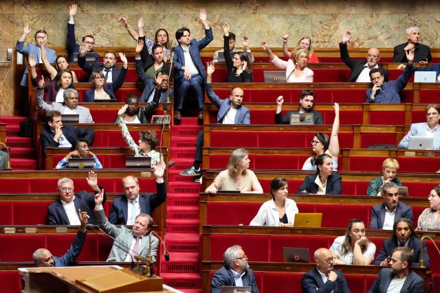 La France Insoumise - Nouveau Front Populaire's MPs vote rising their hands during a session to debate a proposed bill aimed at abolishing the slavery-related laws is adopted by The National Assembly, France's lower house parliament, in Paris on May 28, 2026. These laws, known as Code Noir ("Black Code") classified enslaved people as "chattels" that could be acquired by a master in the same way as property, or established penalties for escapeincluding the cutting off of ears, branding with a lily, and even the death penalty. (Photo by Ludovic MARIN / AFP)