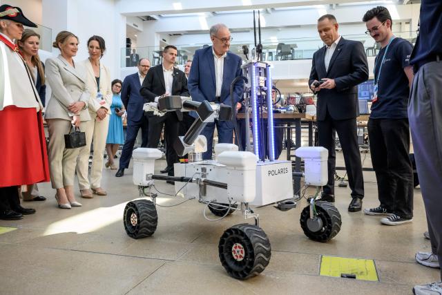 Poland's President Karol Nawrocki (2nd R) remotely controls the Mars rover Polaris of the Xplore project next to Switzerland's President Guy Parmelin (C) and Poland's first lady Marta Nawrocka (3rd L) during his visit at the Swiss Federal Institute of Technology of Lausanne (EPFL) in Ecublens on May 28, 2026. Nawrocki is on two-day state visit in Switzerland. (Photo by Fabrice COFFRINI / AFP)