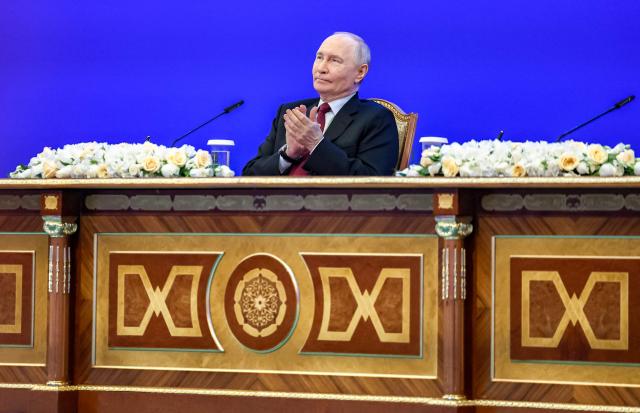 In this pool photograph distributed by the Russian state agency Sputnik Russian President Vladimir Putin applauds during a meeting with Kazakh President at the Palace of Independence during his state visit to Kazakhstan in Astana on May 28, 2026. (Photo by Alexander KAZAKOV / POOL / AFP)