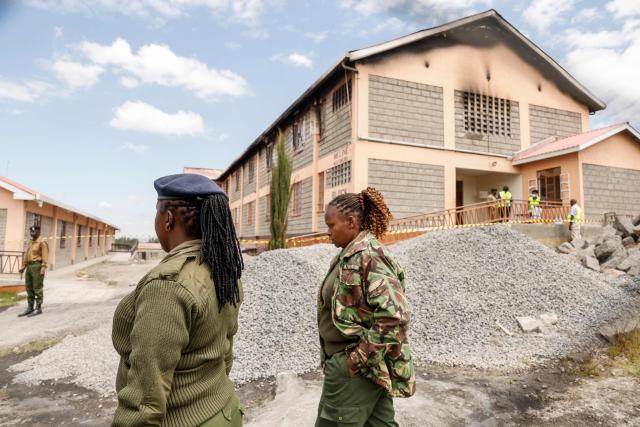 Kenyan police officers and forensic experts gather around the building at Utumishi Girls Academy where a deadly fire took place in Nakuru, north of the capital Nairobi on May 28, 2026. A fire in a girls' dormitory in Kenya on May 28 killed 16 children and hospitalised 79 in the latest deadly blaze to hit a school in the east African country. The fire broke out shortly before 1:00 am local time at Utumishi Girls Academy in Nakuru County, around 120 kilometres (75 miles) north of the capital Nairobi, officials said. (Photo by SIMON MAINA / AFP)