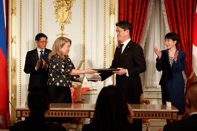 Philippines' President Ferdinand Marcos Jr (L) and Japanese Prime Minister Sanae Takaichi  (R) applaud as Ambassador of the Philippines to Japan Mylene J. Garcia-Albano (2nd L) and Ambassador of Japan to the Philippines Kazuya Endo (2nd R) exchange documents during the Cooperation Document Exchange Ceremony at the Akasaka Palace State Guest House in Tokyo on May 28, 2026. (Photo by Rodrigo Reyes Marin / POOL / AFP)