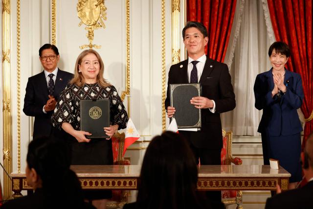 Philippines' President Ferdinand Marcos Jr (L) and Japanese Prime Minister Sanae Takaichi  (R) applaud as Ambassador of the Philippines to Japan Mylene J. Garcia-Albano (2nd L) and Ambassador of Japan to the Philippines Kazuya Endo (2nd R) exchange documents during the Cooperation Document Exchange Ceremony at the Akasaka Palace State Guest House in Tokyo on May 28, 2026. (Photo by Rodrigo Reyes Marin / POOL / AFP)